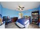 This blue bedroom has a ceiling fan, plank floors and playful decor at 3994 Belmoor Dr, Palm Harbor, FL 34685