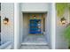 Inviting entryway features a bright blue front door with sidelights and stylish exterior lighting at 3994 Belmoor Dr, Palm Harbor, FL 34685