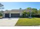 Charming single-story home with a well-maintained lawn, mature landscaping, and a spacious driveway leading to a two-car garage at 3994 Belmoor Dr, Palm Harbor, FL 34685