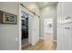 Hallway with closet featuring barn door and wood-look floors leading to the bathroom at 3994 Belmoor Dr, Palm Harbor, FL 34685