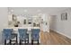 Open-concept kitchen with white cabinets, modern appliances, and a breakfast bar with designer chairs at 3994 Belmoor Dr, Palm Harbor, FL 34685