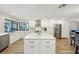 Bright kitchen with white cabinets, stainless steel appliances, a large island, and lots of natural light at 3994 Belmoor Dr, Palm Harbor, FL 34685