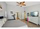 Bright main bedroom featuring a ceiling fan, wood-look floors, and home gym equipment at 3994 Belmoor Dr, Palm Harbor, FL 34685