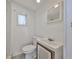 Small bathroom featuring toilet, small vanity, window and mirror at 4509 10Th N Ave, St Petersburg, FL 33713