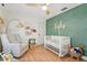 Charming Bedroom featuring a whimsical design, a comfortable chair, and a cozy crib for your little one at 505 Timber Pond Dr, Brandon, FL 33510