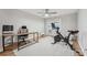 Bright home gym with desk, exercise bike, ceiling fan, light-colored wood floors, and access to the outside at 505 Timber Pond Dr, Brandon, FL 33510