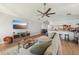 Open-concept living room flows to kitchen, featuring plank floors, sectional sofa, and a modern TV console at 505 Timber Pond Dr, Brandon, FL 33510