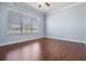 Bright bedroom with wood-look flooring, neutral paint and large window at 5050 Alderbrook Pl, Land O Lakes, FL 34638