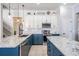 Well-lit kitchen with white upper cabinets, blue lower cabinets, and a large granite-topped island at 5050 Alderbrook Pl, Land O Lakes, FL 34638