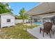 Backyard featuring covered outdoor seating, shed, and fence and partial view of pool at 5103 Town N Country Blvd, Tampa, FL 33615