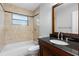 Bathroom featuring stylish tile, a tub/shower combo, and a vanity with black countertop at 5103 Town N Country Blvd, Tampa, FL 33615