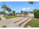 Street view of home showing carport, yard, and proximity to neighborhood at 5103 Town N Country Blvd, Tampa, FL 33615
