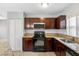 This kitchen features stainless appliances, granite counters, and dark wood cabinetry at 5103 Town N Country Blvd, Tampa, FL 33615
