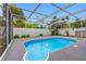 Refreshing in-ground pool featuring clean blue water, screened-in enclosure, and lush landscaping at 5103 Town N Country Blvd, Tampa, FL 33615