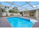 Relaxing in-ground pool surrounded by a screened enclosure for ultimate privacy and enjoyment at 5103 Town N Country Blvd, Tampa, FL 33615