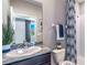 Cozy bathroom featuring granite counters, a single sink, a framed mirror, and a shower with stylish curtain at 5309 Oxford Gray Rd, Wesley Chapel, FL 33545
