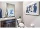 Simple bathroom with a single sink granite vanity, toilet, and modern art enhancing the neutral color palette at 5309 Oxford Gray Rd, Wesley Chapel, FL 33545