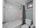 Modern bathroom features a shower and tub with elegant marble-patterned tiling at 8024 Timberlane Dr, Tampa, FL 33615