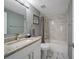 Updated bathroom with granite countertop vanity, marble tile and shower-tub with tiling at 8024 Timberlane Dr, Tampa, FL 33615