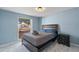 Bedroom featuring a single bed, window view, and a calm, blue color scheme at 8024 Timberlane Dr, Tampa, FL 33615