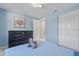 Serene bedroom showcasing soft blue walls, a dresser, and a built-in closet at 8024 Timberlane Dr, Tampa, FL 33615
