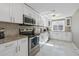 Bright kitchen featuring white cabinets, stainless steel appliances, and granite countertops at 8024 Timberlane Dr, Tampa, FL 33615