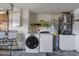 Functional laundry area featuring a modern washer and dryer with utility sink at 8024 Timberlane Dr, Tampa, FL 33615