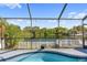 Enclosed pool overlooking a calm lake with lush greenery for serene relaxation at 8024 Timberlane Dr, Tampa, FL 33615