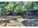 A serene backyard featuring a screened-in porch, small storage shed, and mature trees at 803 W Columbus Dr, Tampa, FL 33602