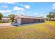 Charming single-story brick home with a metal roof, a long driveway, and a storage shed at 8122 Ehren Cemetery Rd, Land O Lakes, FL 34639