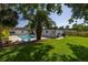 Lush backyard featuring a sparkling pool, spacious lawn, and tropical palm trees for outdoor enjoyment at 1101 39Th Ne Ave, St Petersburg, FL 33703