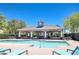 Inviting community pool with a shaded pavilion, lounge chairs, and beautiful landscaping at 12646 Carlby Cir, Tampa, FL 33626