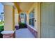 Welcoming porch view showing brick columns, manicured shrubbery, and neutral-toned accents at 12646 Carlby Cir, Tampa, FL 33626