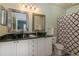 Bathroom featuring dual sinks, granite counters, and a patterned shower curtain at 1304 High Hammock Dr # 106, Tampa, FL 33619