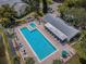 Aerial view showcasing a pool with lounge area near a lake and clubhouse at 1333 Shady Pine Way # F, Tarpon Springs, FL 34688