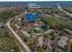 Aerial view of condo complex featuring a clubhouse, playground, pool, tennis courts and lush landscaping at 1333 Shady Pine Way # F, Tarpon Springs, FL 34688