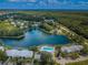 Aerial view of the community, featuring a serene lake and a beautiful pool area surrounded by lush greenery at 1333 Shady Pine Way # F, Tarpon Springs, FL 34688