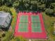Aerial view featuring well-maintained tennis courts, lush greenery, and beautiful landscaping in a well-kept community at 1333 Shady Pine Way # F, Tarpon Springs, FL 34688