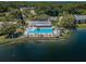 Community aerial view of a pool area next to a lake with lush green surroundings at 1333 Shady Pine Way # F, Tarpon Springs, FL 34688