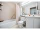 Bright bathroom featuring a shower-tub combo, white tile, and neutral-toned walls at 1333 Shady Pine Way # F, Tarpon Springs, FL 34688