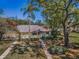 Exterior shot of a single-story home with a charming fenced yard surrounded by mature trees, offering a serene setting at 1333 Shady Pine Way # F, Tarpon Springs, FL 34688