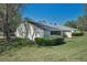 Charming exterior view featuring a well-manicured lawn, mature trees, and a beautiful backyard at 1333 Shady Pine Way # F, Tarpon Springs, FL 34688