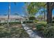 Charming single-story home with a well-maintained yard, complemented by mature trees and a bright blue sky at 1333 Shady Pine Way # F, Tarpon Springs, FL 34688