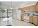 Well-lit kitchen with wooden cabinets, standard appliances, and an adjacent dining area at 1333 Shady Pine Way # F, Tarpon Springs, FL 34688