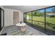 Comfortable screened lanai with a table setting and peaceful views of the surrounding outdoor landscape at 1333 Shady Pine Way # F, Tarpon Springs, FL 34688