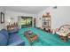Inviting living room showcasing rattan furniture, a coffee table, and a sliding glass door to the lanai at 1333 Shady Pine Way # F, Tarpon Springs, FL 34688