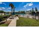 Community picnic area featuring BBQ, picnic table, grassy space, and views of the lake and pool at 1333 Shady Pine Way # F, Tarpon Springs, FL 34688