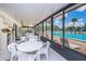 Bright pool area with seating, sun loungers, and a view of the outdoor pool through large, sunlit windows at 1333 Shady Pine Way # F, Tarpon Springs, FL 34688