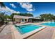 Relaxing pool area with hot tub, community building, lounge chairs, and lush landscaping at 1333 Shady Pine Way # F, Tarpon Springs, FL 34688