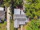 An overhead aerial view reveals a home with a silver roof surrounded by mature trees offering shade and privacy at 1401 E North St, Tampa, FL 33604